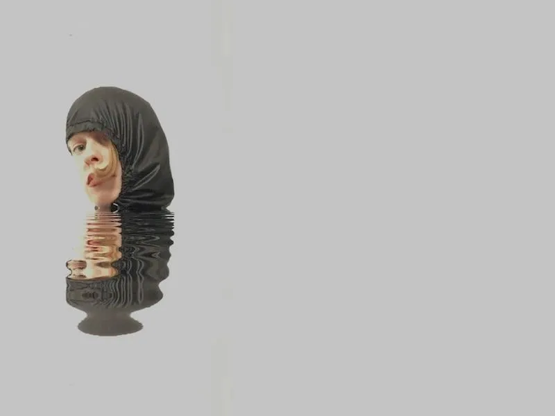 Surreal image of a hooded figure above a rippled reflection on a grey background