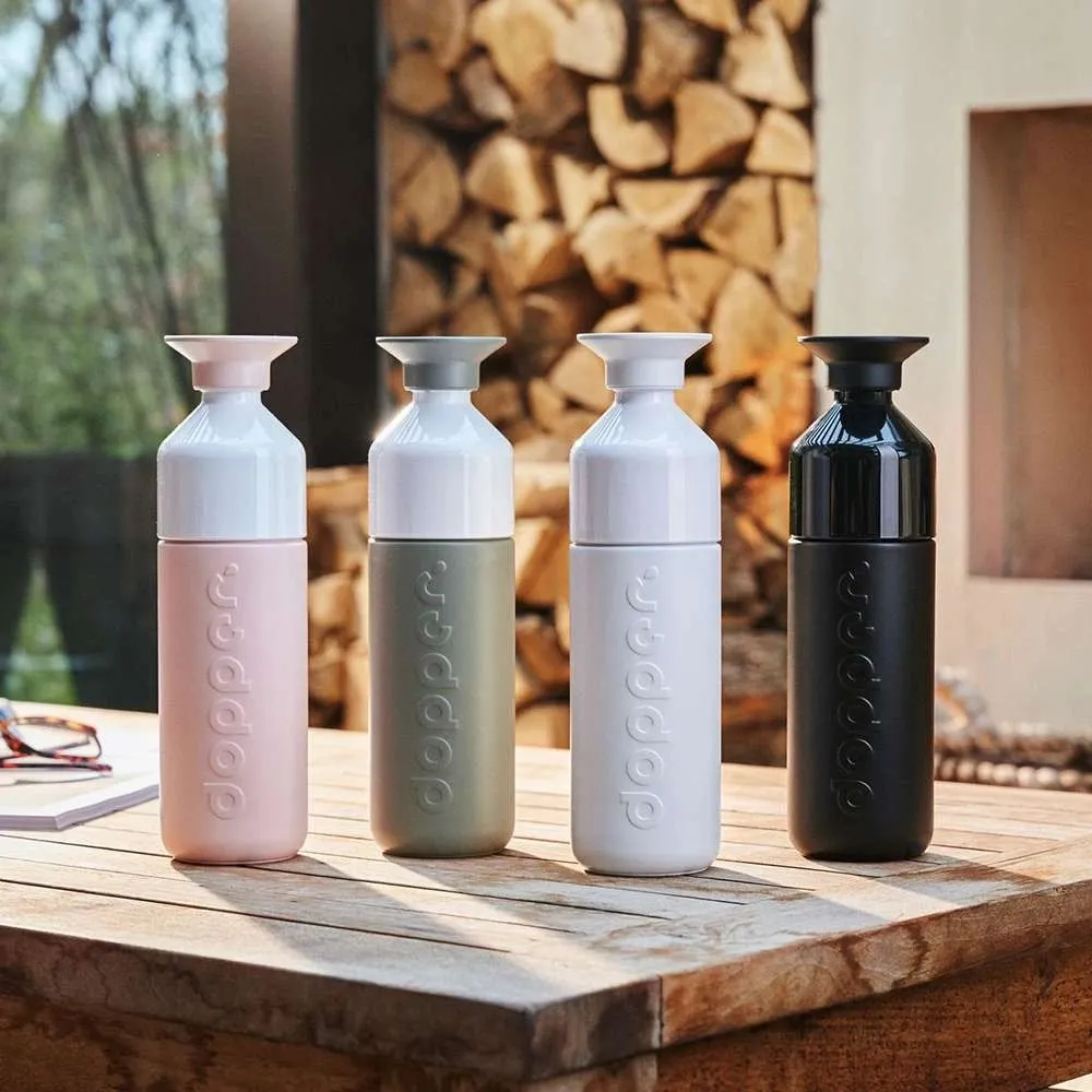 Four Dopper insulated bottles on a wooden table