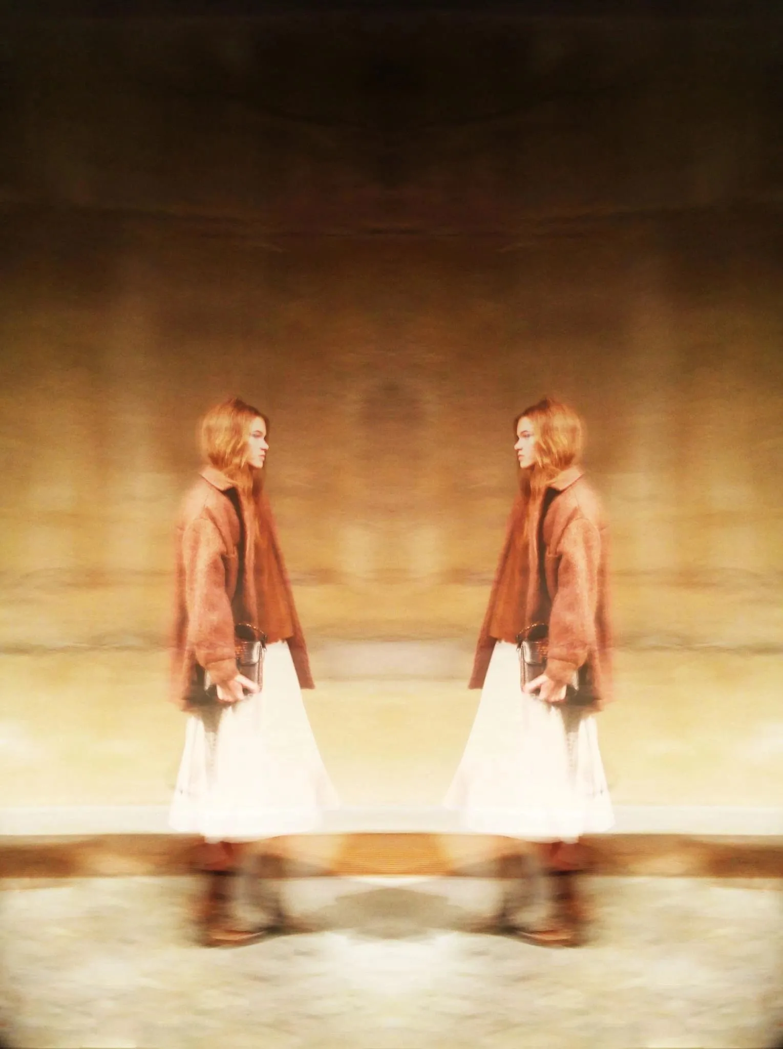 Mirrored image of a figure in a brown coat and white skirt