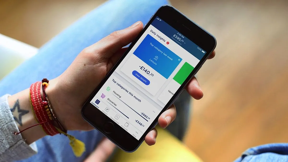 Hand holding a phone showing the Yolt app